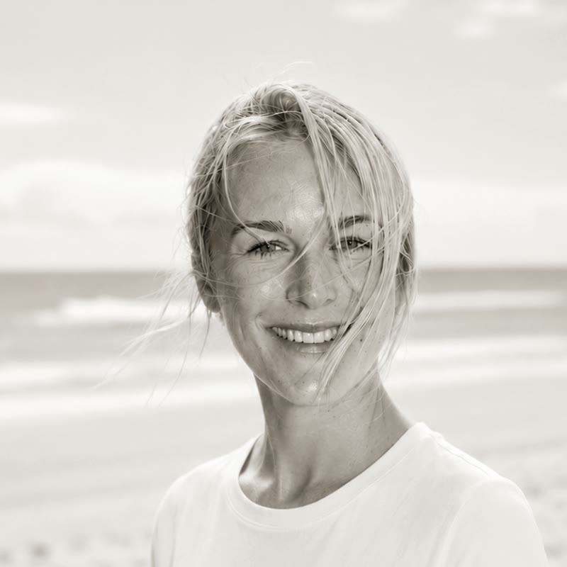 Alina am Strand, l&auml;chelnd, das Meer im R&uuml;cken